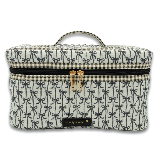 Quilted train case with dark blue patterned fabric and zip closure, top handle