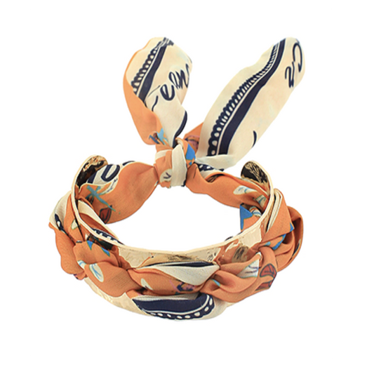 Orange patterned scarf bracelet with a twisted fabric loop design