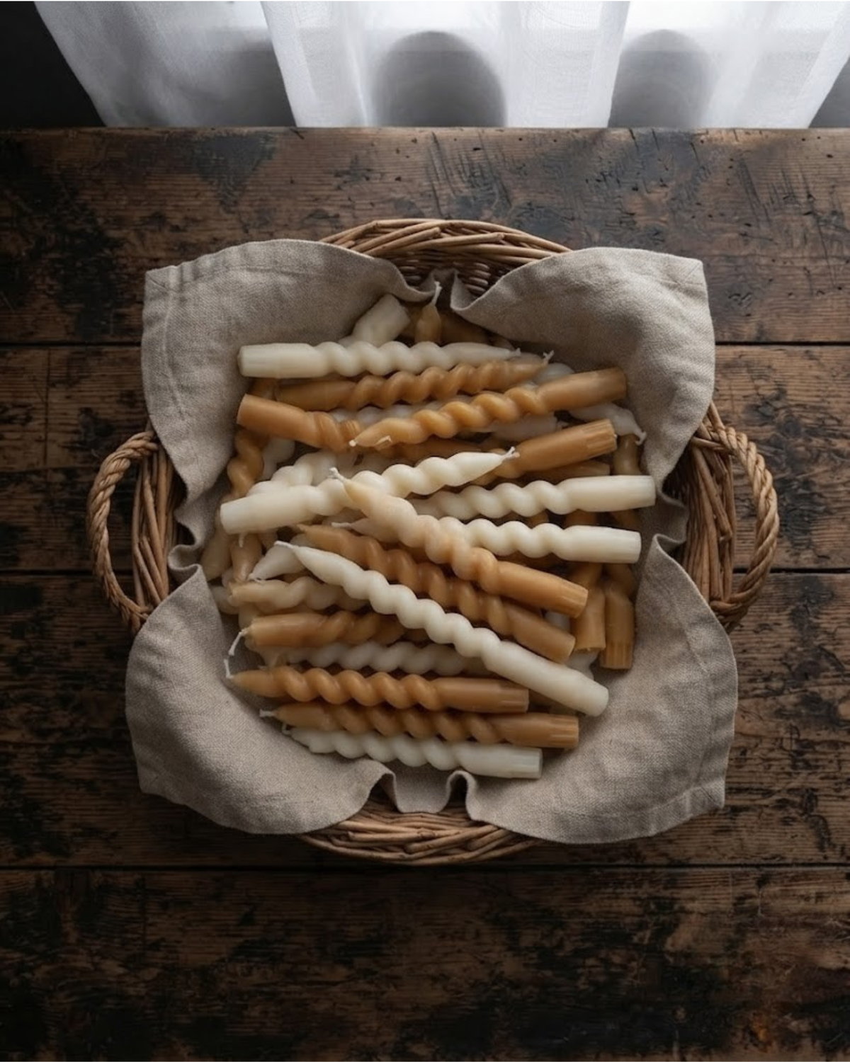 Swirl taper candles in a cloth-lined basket, mixed white and brown