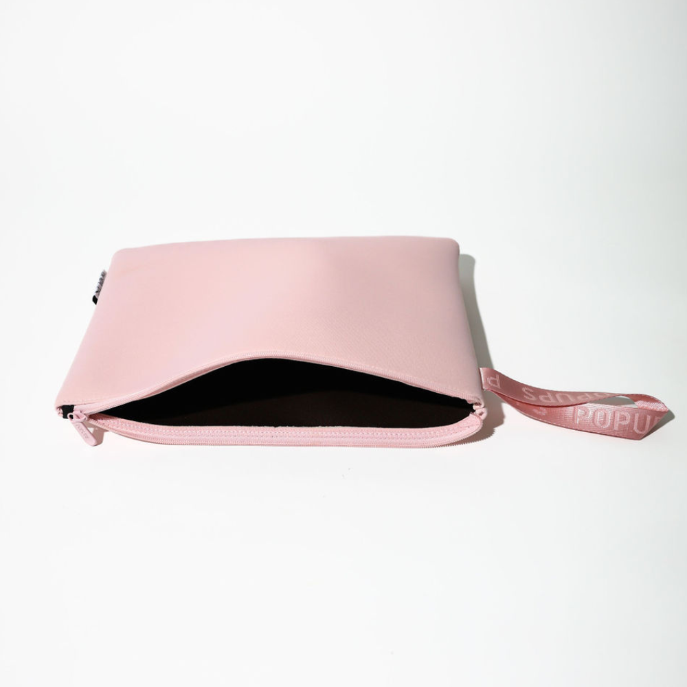 Pink laptop sleeve opened to show dark interior lining and zip pocket edge