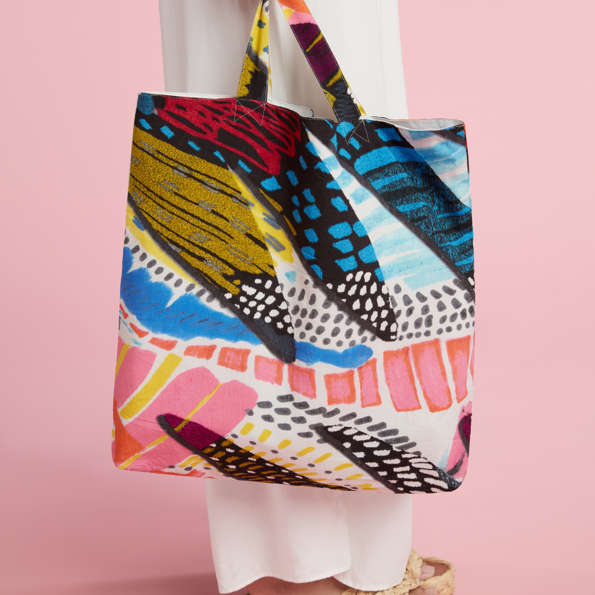Farmers' market tote bag with colorful abstract print, held on shoulder