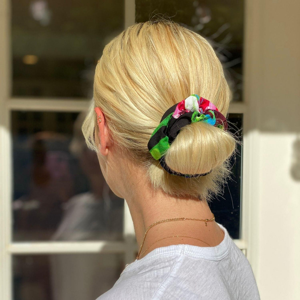 Floral scrunchie in green and pink, gathered elastic, worn on blonde ponytail