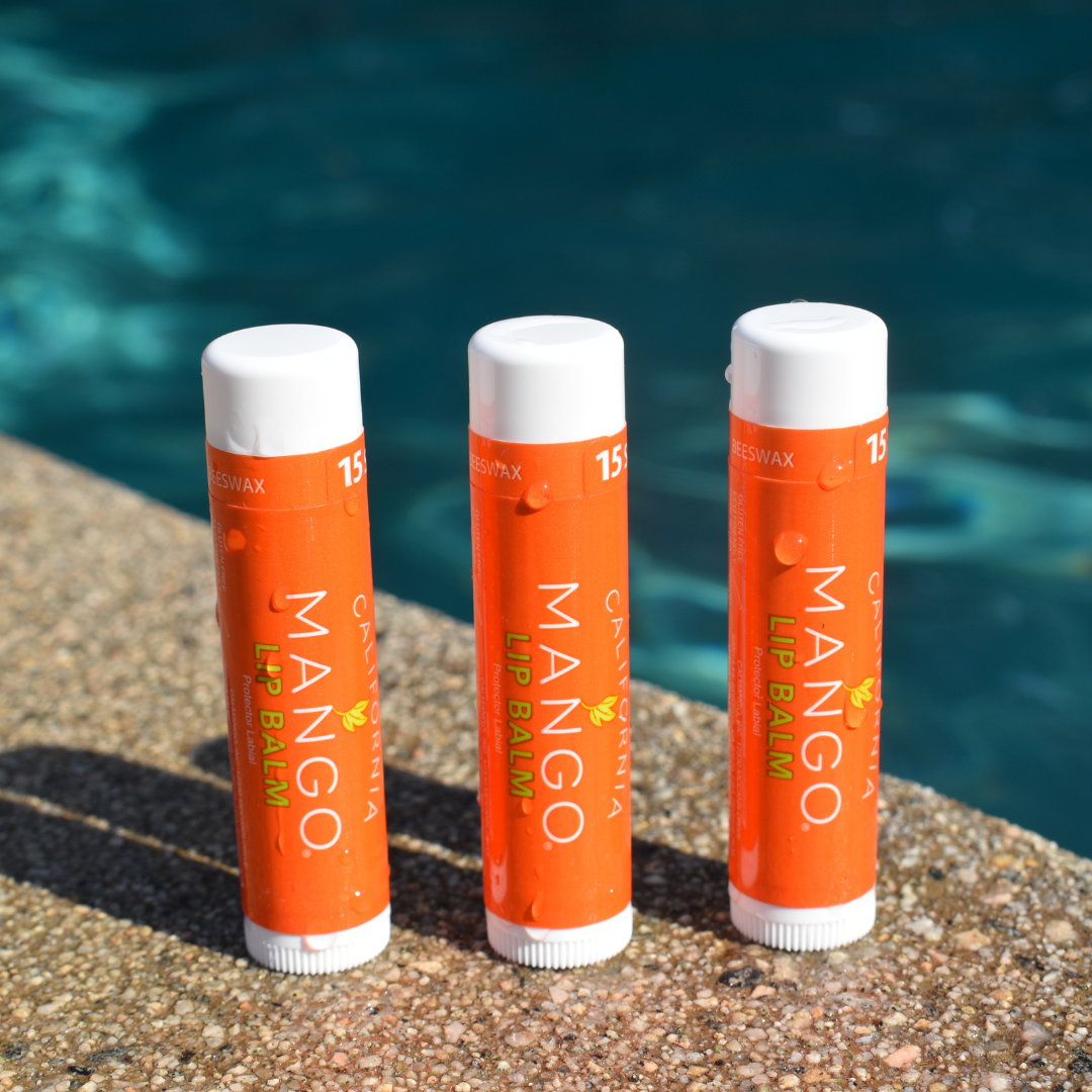 Three orange mango lip balm tubes with white caps