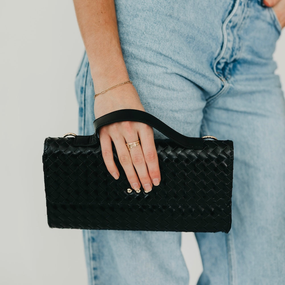 Black woven foldover clutch bag with snap front and chain shoulder strap