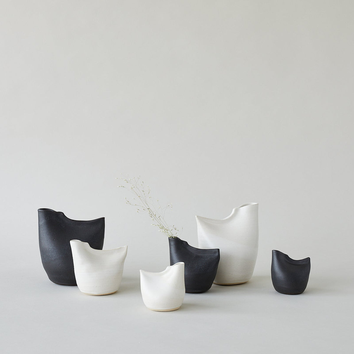 Black and white bird vases set, each with smooth curved body and open top.