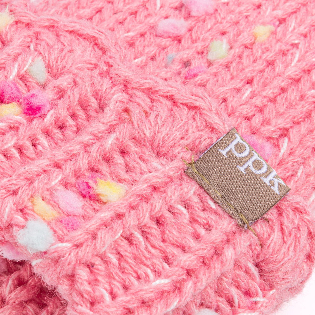 Close-up of pink speckled mitten knit and sewn brand label