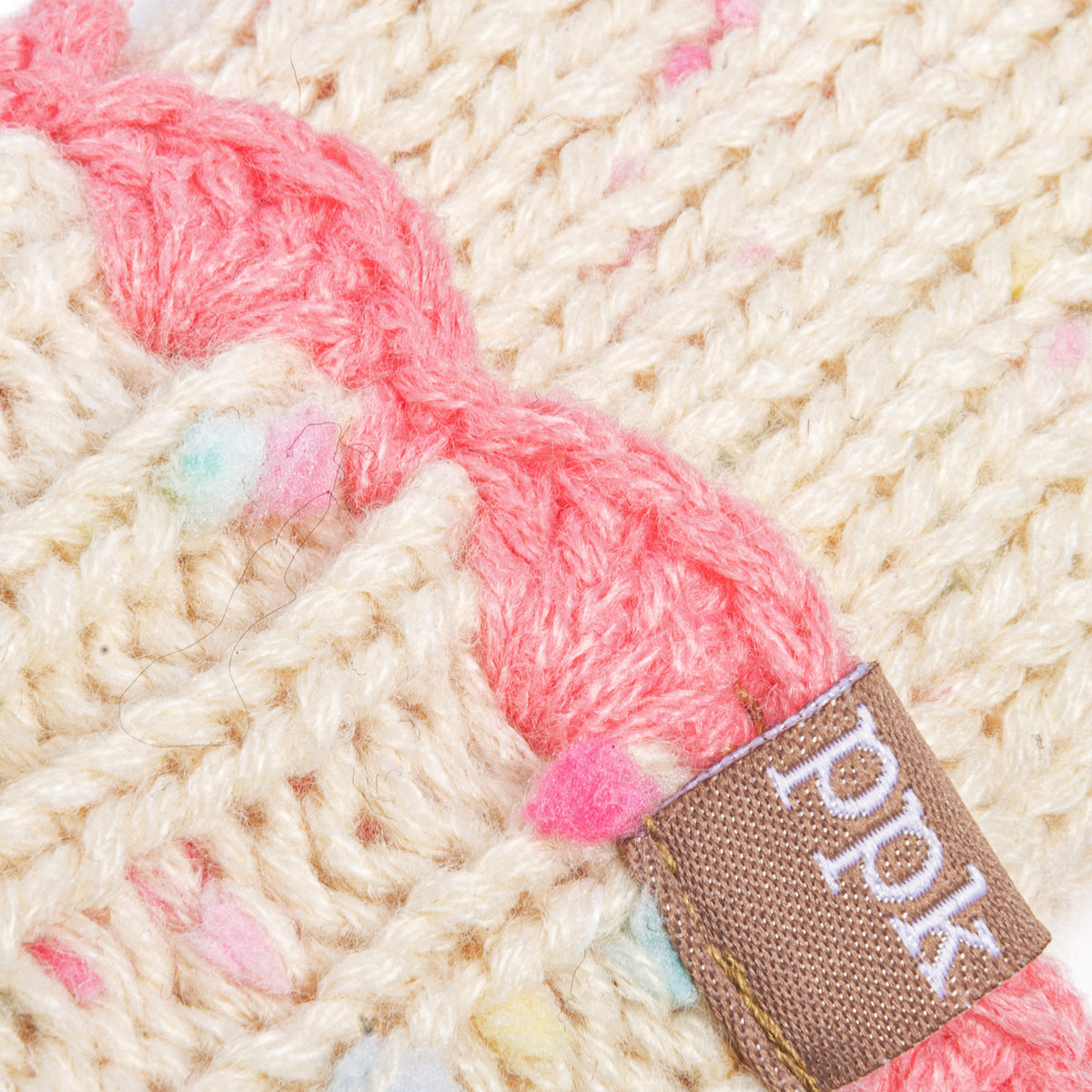 Speckled knit mitten with a pink braided tie and brown fabric label