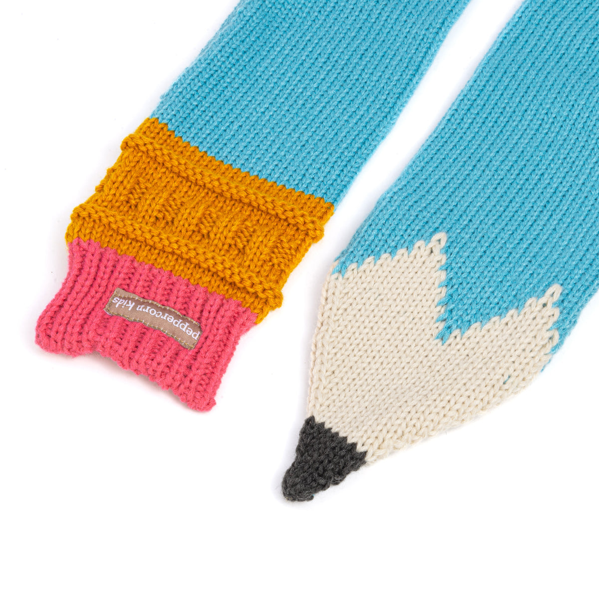 Close-up of knitted scarf ends with cream pencil point and ribbed cuffs