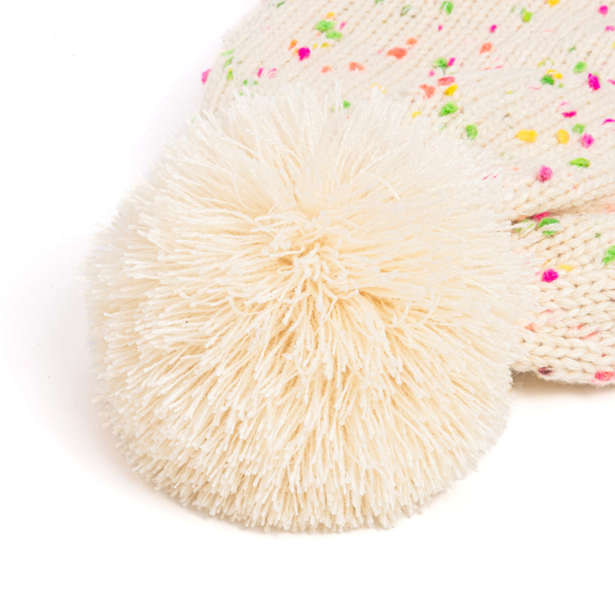 Close-up of fluffy pom-pom on a cream knit hat with colorful flecks