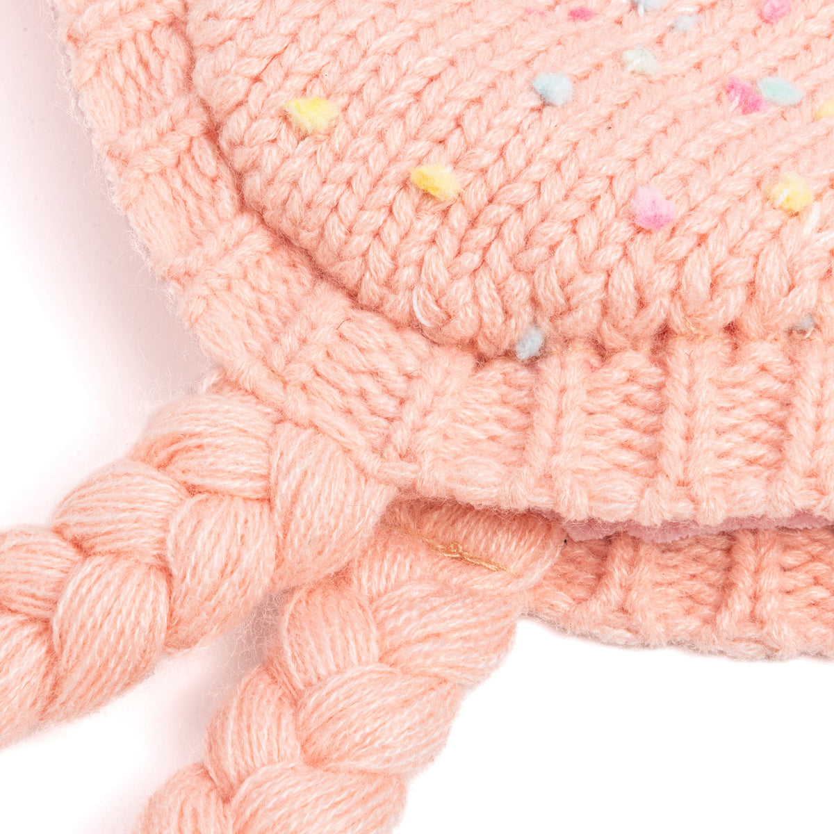 Close-up of coral-pink knit earflap hat with colorful flecks and braided ties