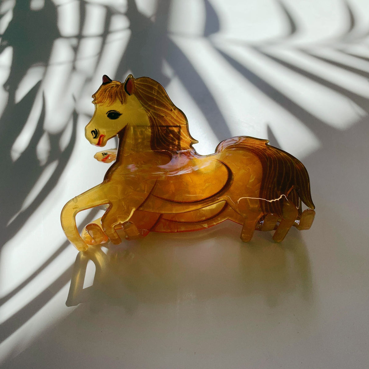 Glossy amber gold horse hair claw with full mane detail and curved prongs