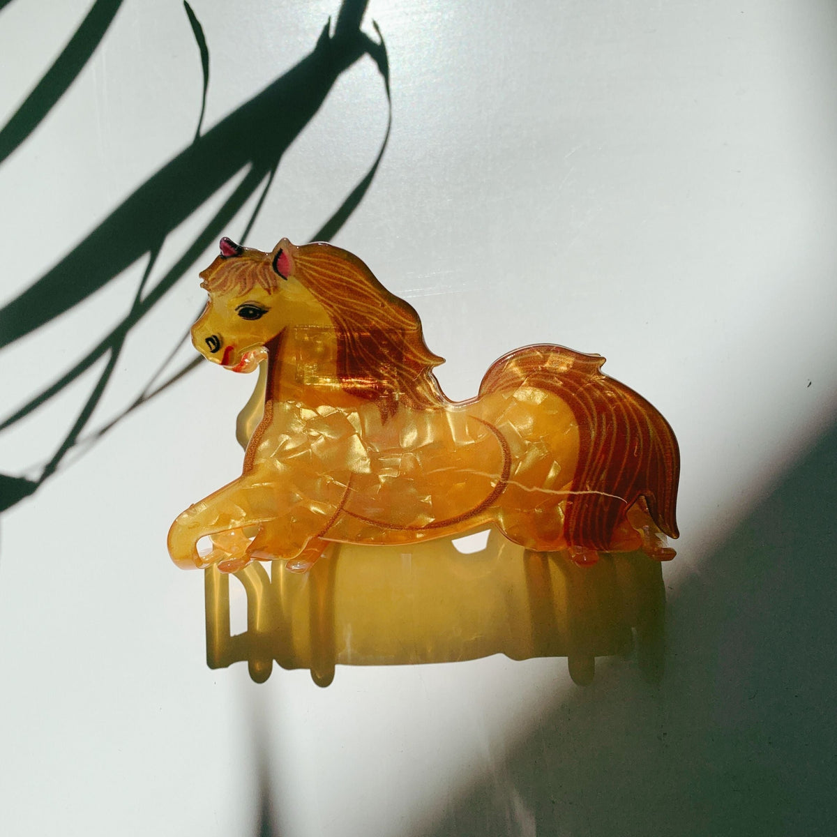 Glowing gold horse hair claw ornament with curved base and holding prongs