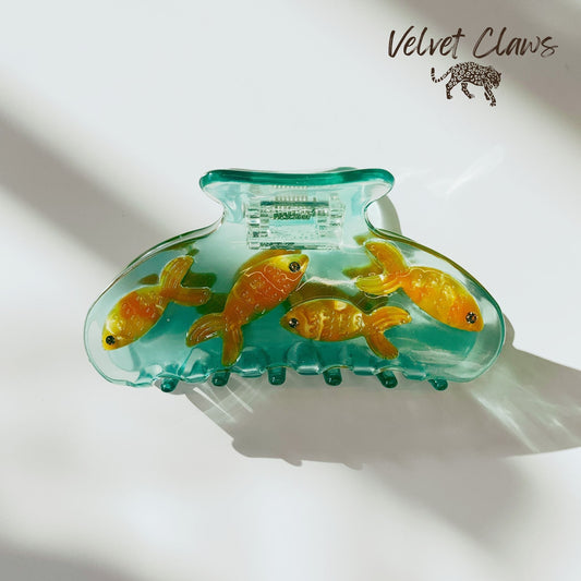 Goldfish hair claw clip with transparent teal shell and golden fish details