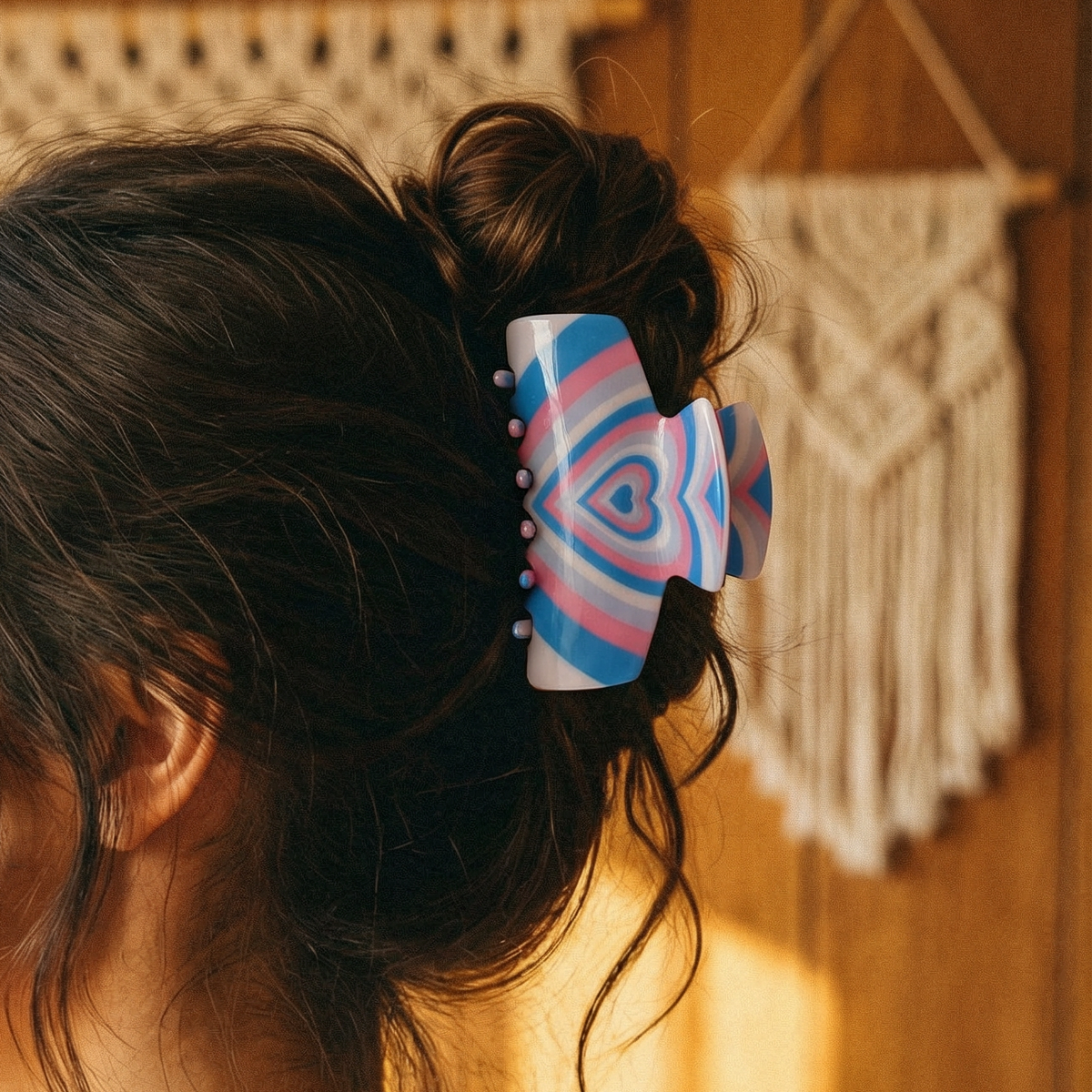 Hair claw clip with blue and red stripes and a heart design on dark hair