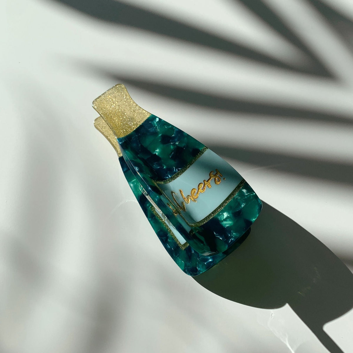 Teal and blue marbled hair claw with gold glitter top and curved prong style