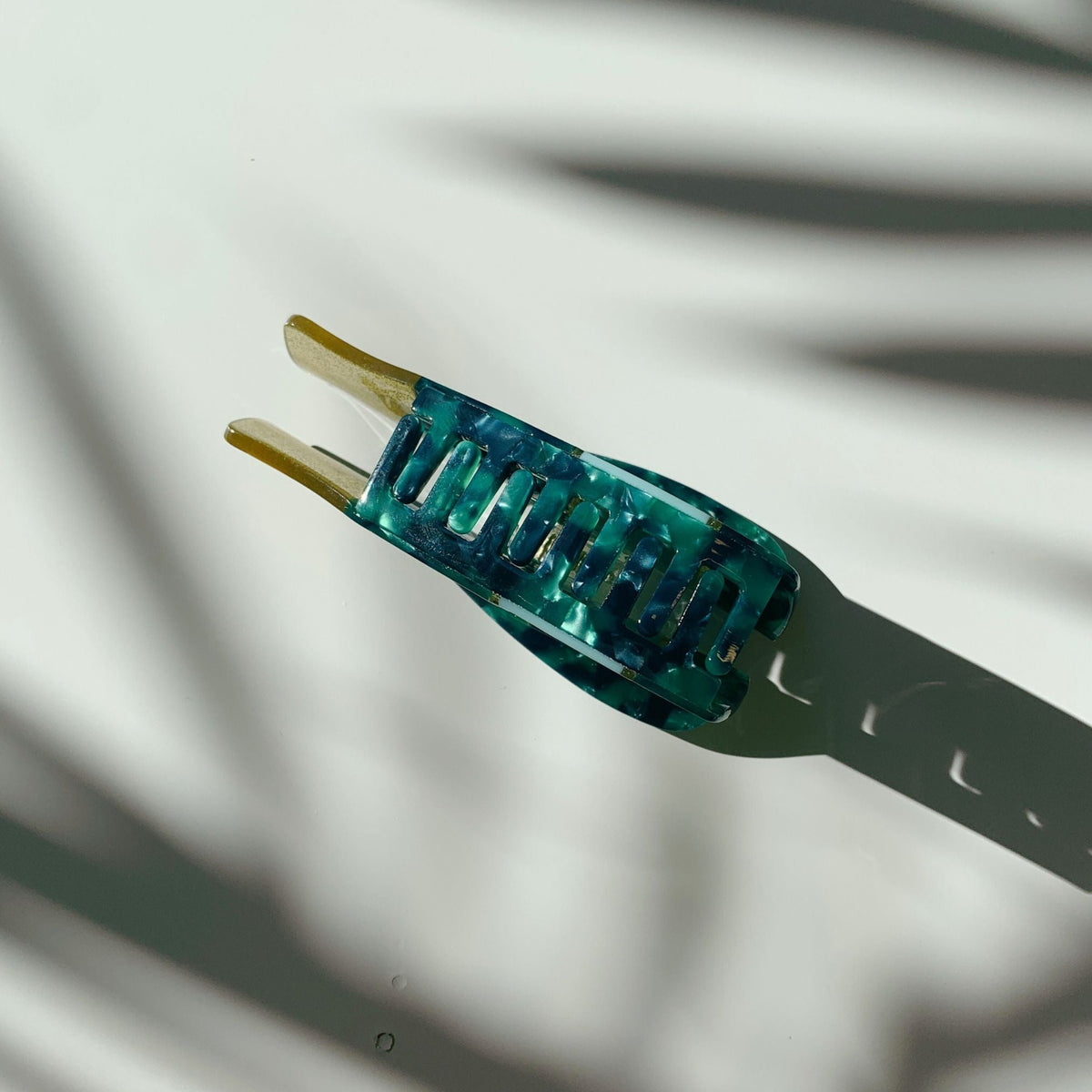 Teal hair claw back view with gold glitter prongs and comb-like teeth