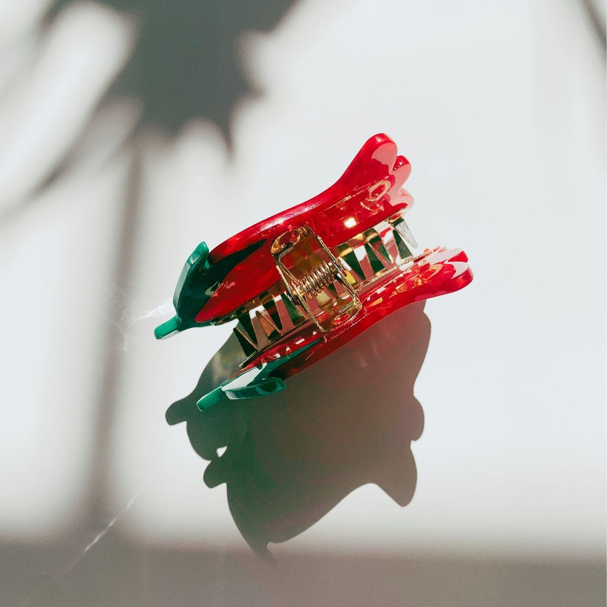Small red rosebud hair claw clip with gold spring and clear base teeth