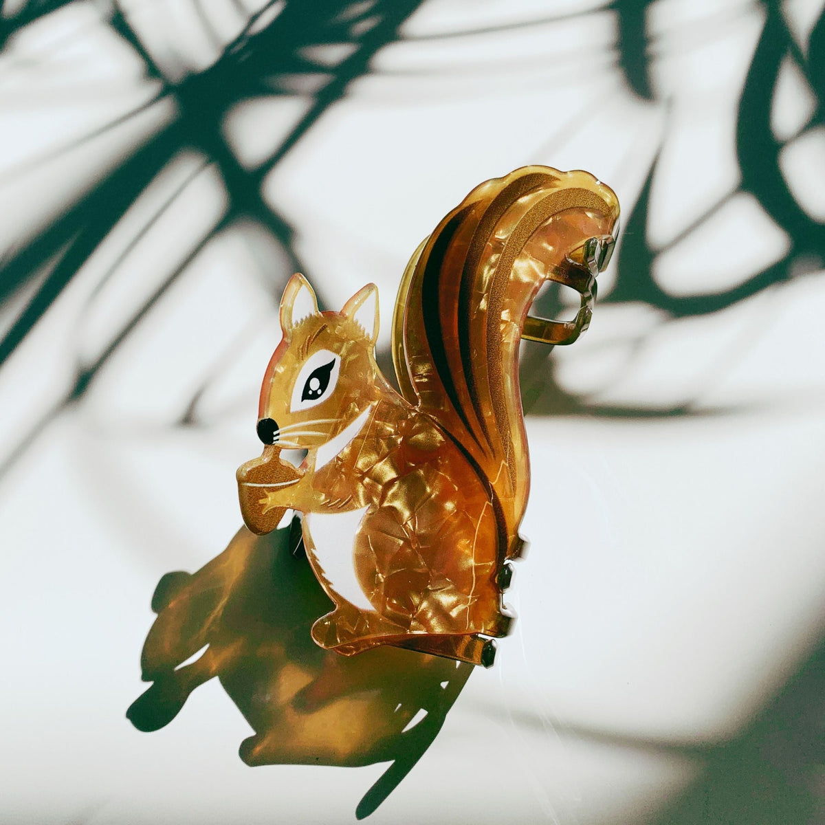 Amber squirrel hair claw with acorn details and curved metal clasp