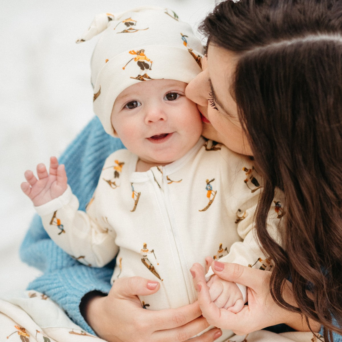 Cream knotted beanie hat with animal pattern on baby's head