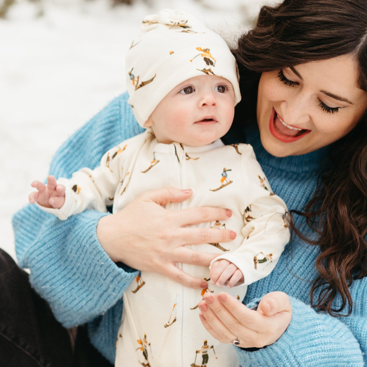 Baby wearing tulip-print knotted beanie hat, light green with pink flowers