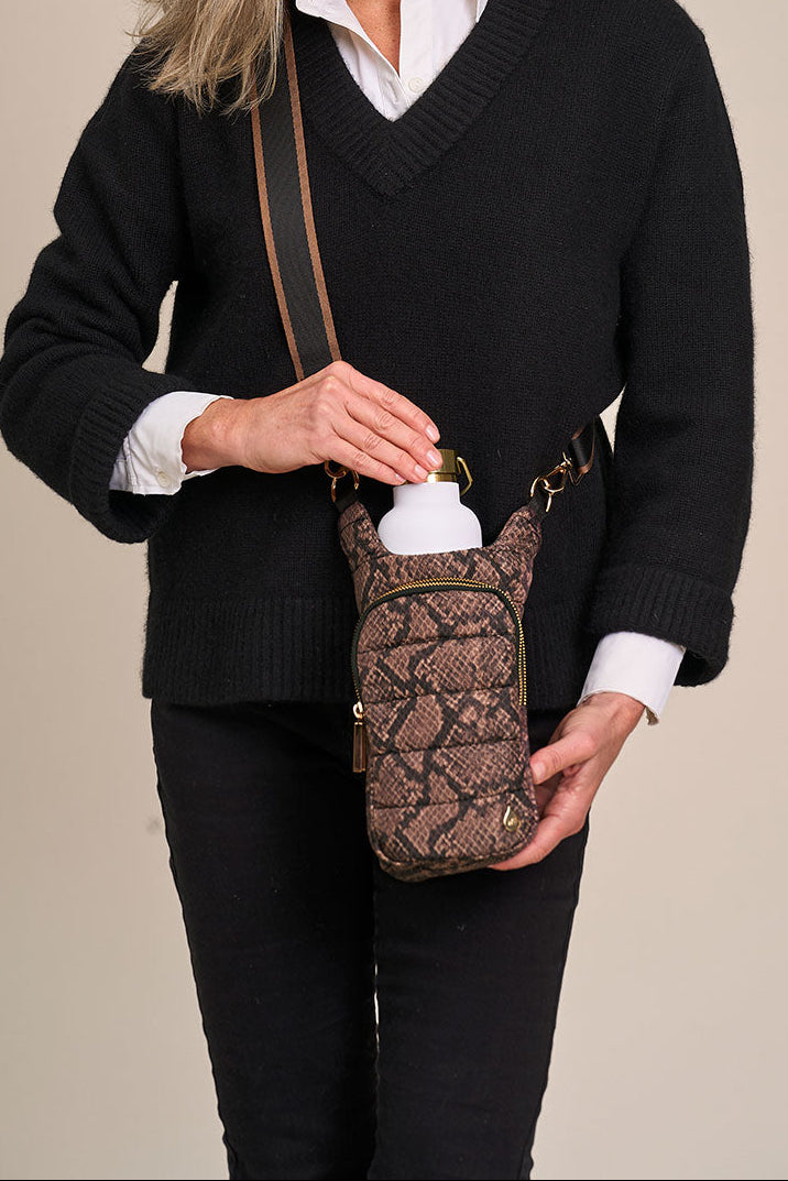 Snake-print crossbody HydroBag worn with black sweater, gold-toned hardware and front pocket