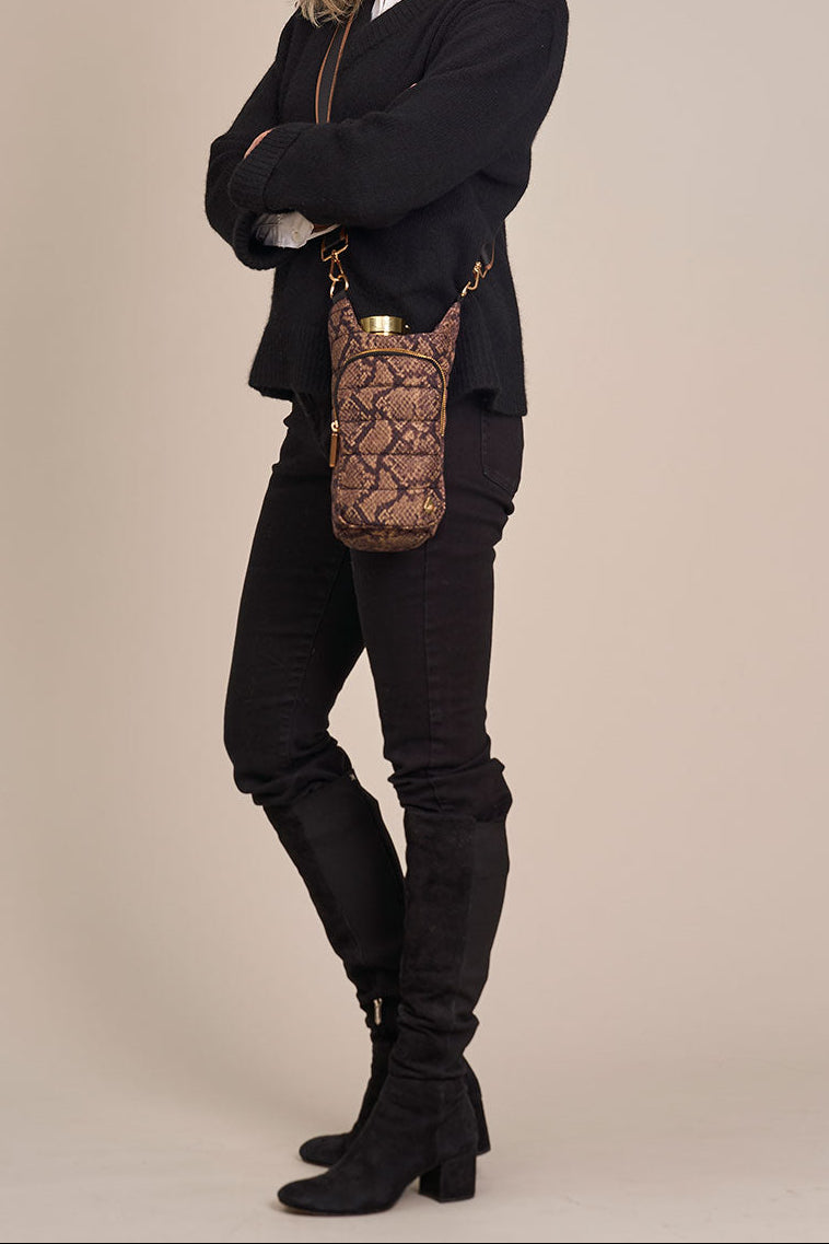 Snake-print HydroBag crossbody worn with black outfit, gold zippers and top handle