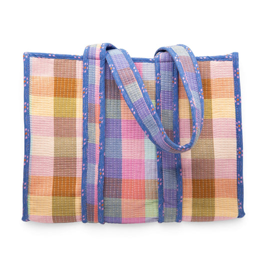 Plaid woven tote bag with blue ribbon-tied handles and multicolor patchwork panels