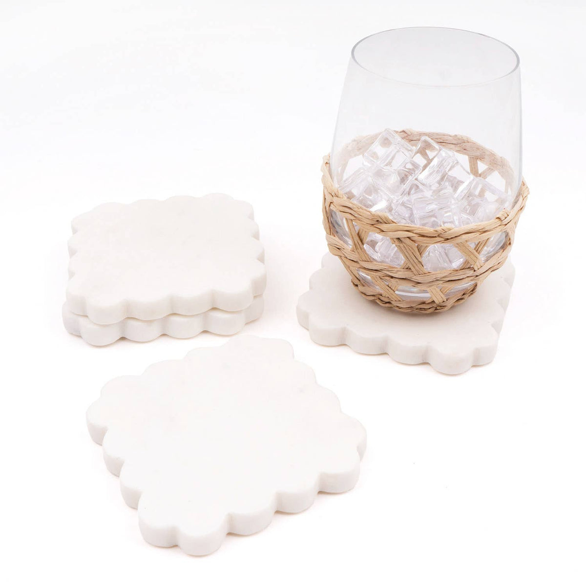 Scalloped white coasters with marble pattern, four pieces in a woven basket