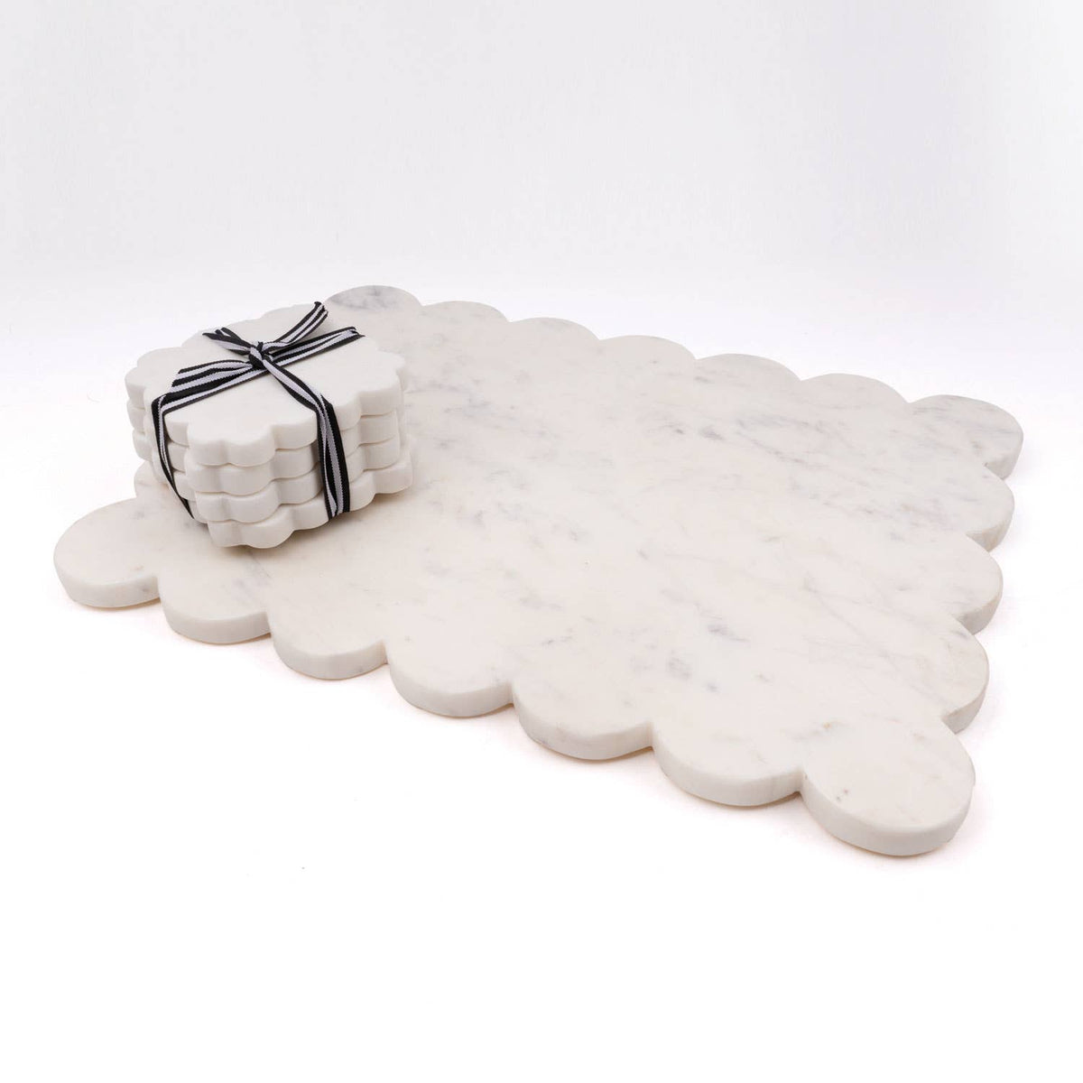 Large white marble scalloped coaster with small stacked coasters tied by ribbon