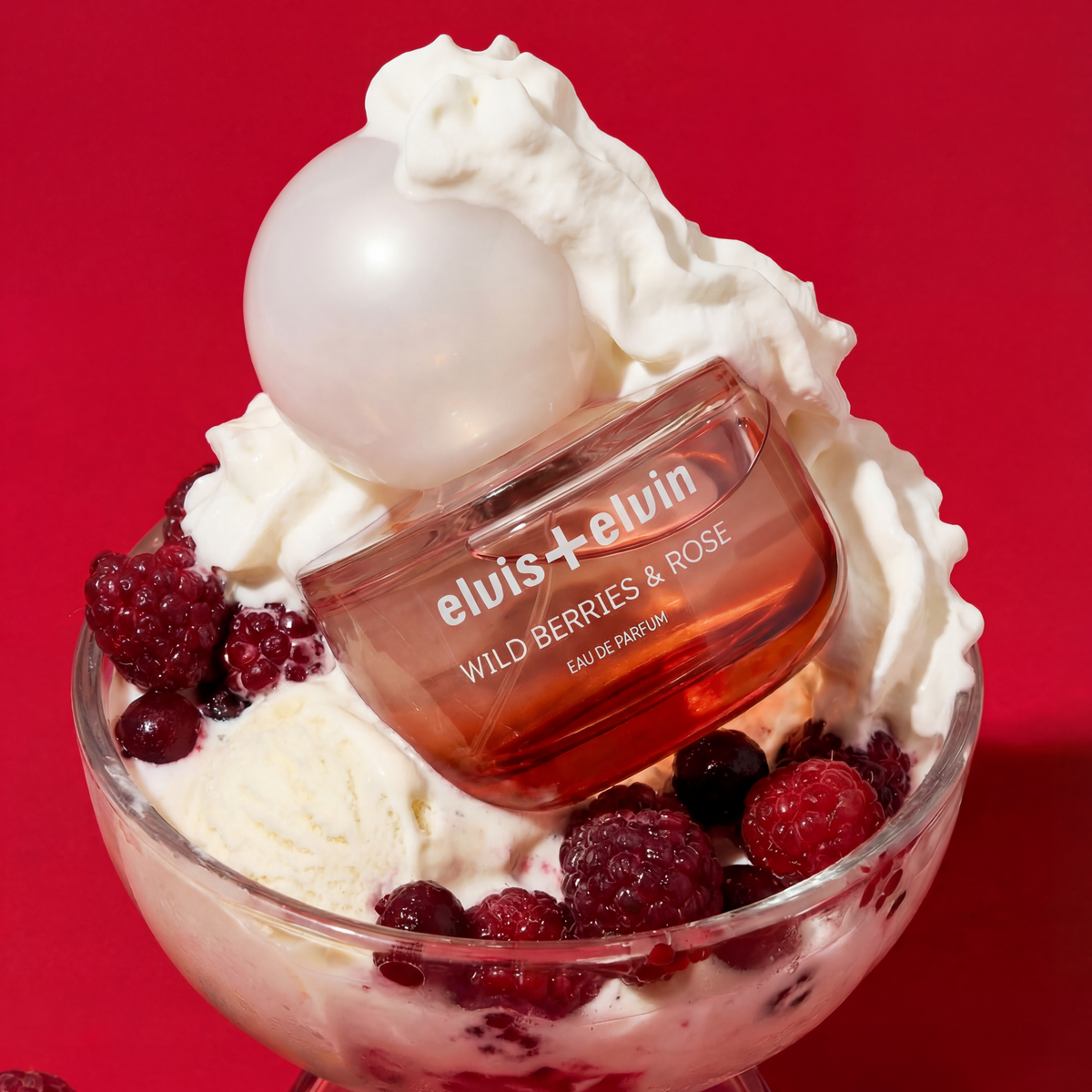 Wild Berries & Rose eau de parfum bottle with berry-filled glass and cream swirl