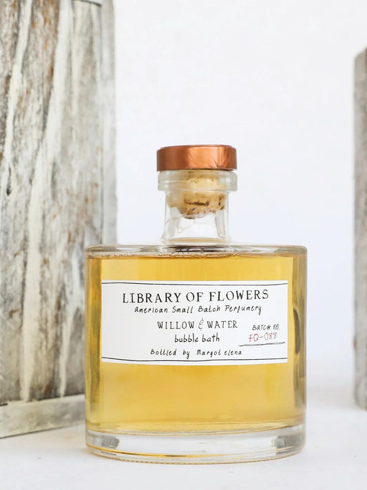 Yellow bubble bath bottle with copper cap and frosted label, 'Library of Flowers'.
