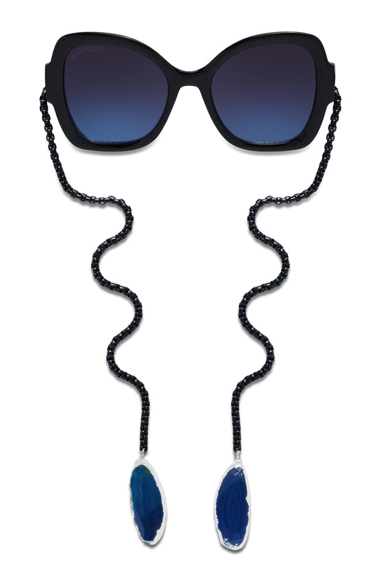 Black oversized sunglasses with blue gradient lenses and long bead chains with teardrop pendants