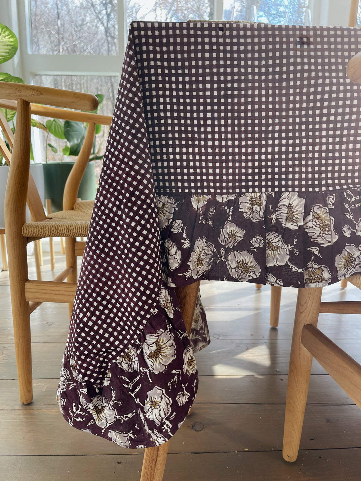Close view of the wine gingham tablecloth's floral ruffled edge