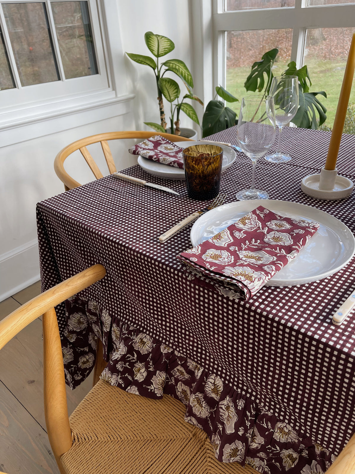 Wine gingham tablecloth with a floral ruffled skirt and matching floral napkins