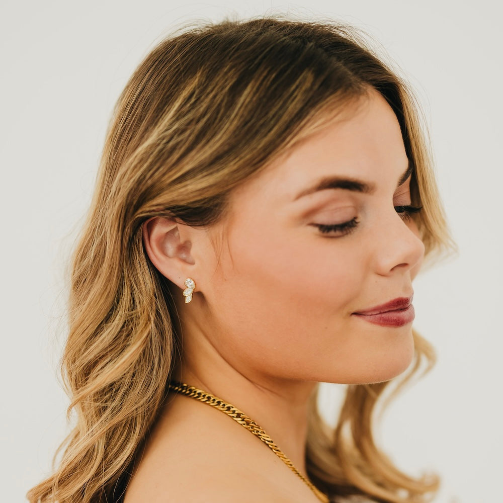Gold-tone angel wing stud earrings with crystal-like stones