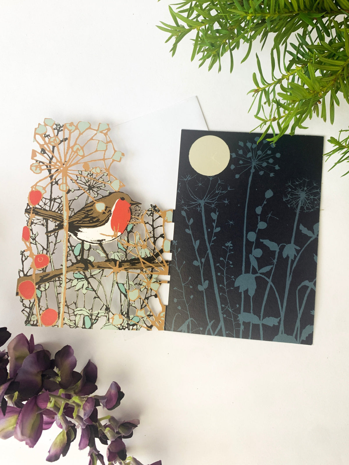Pair of Christmas cards featuring a robin design and a blue forest silhouette