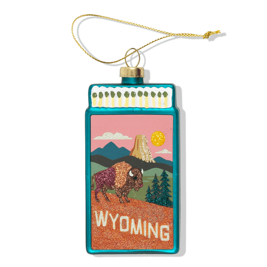 Wyoming matchbook ornament with landscape scene and hanging loop, gold string.