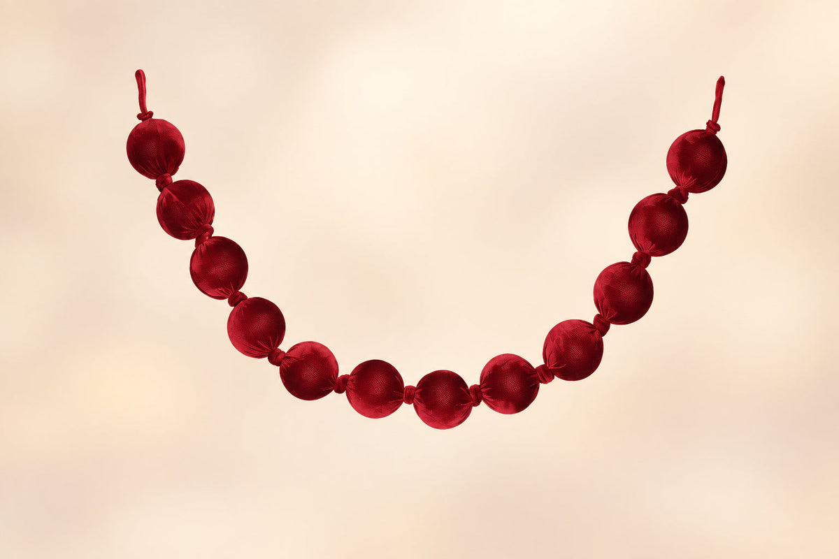 Burgundy velvet ball garland with round ornaments strung in a curved line