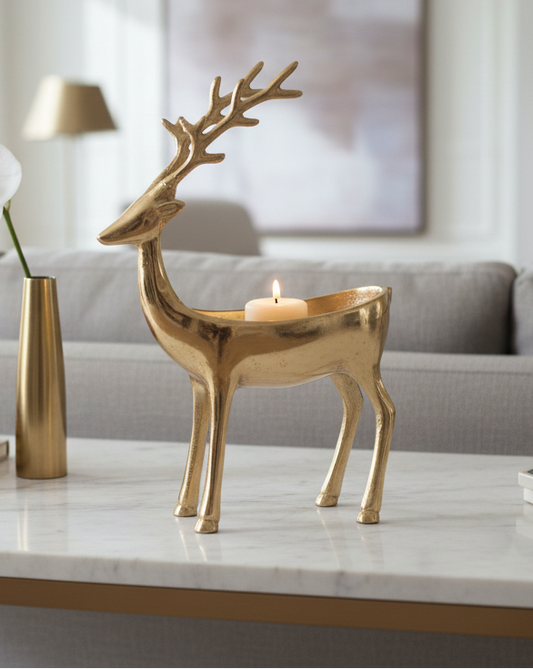 Gold-toned aluminum bowl shaped like a deer with branching antlers and a lit candle inside