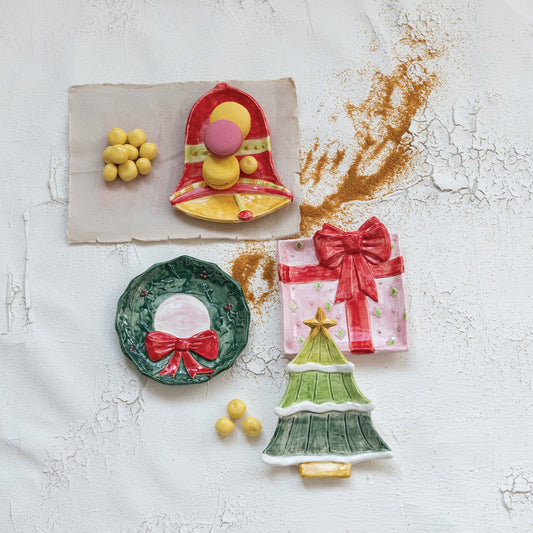 Christmas tidbit dish icons arranged with small decorations: bell, tree, wreath, and present