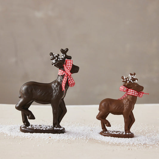 Two dark brown resin deer figurines, red gingham bows, sprinkles on bases