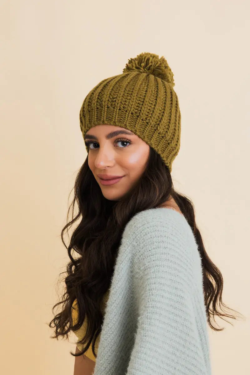 Army green chunky cable knit pom beanie, side view with ribbed texture