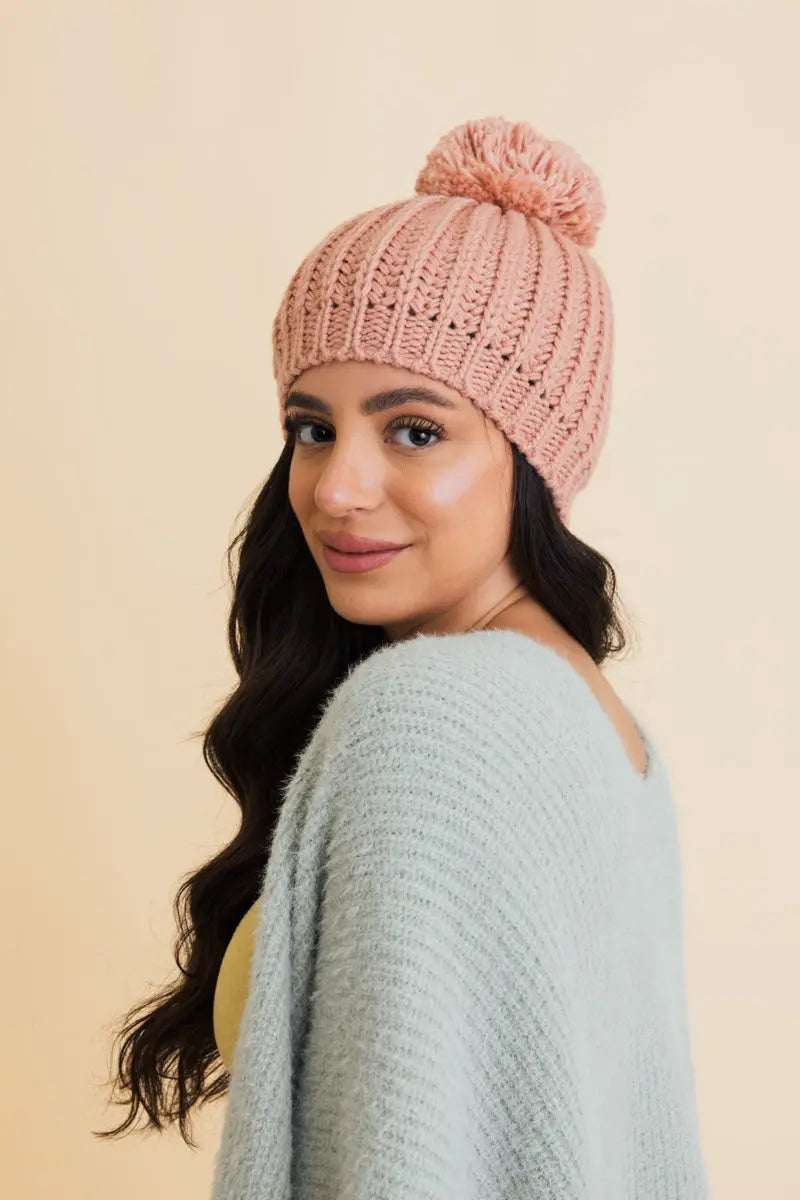 Blush pink chunky cable knit pom beanie, side profile with pom top