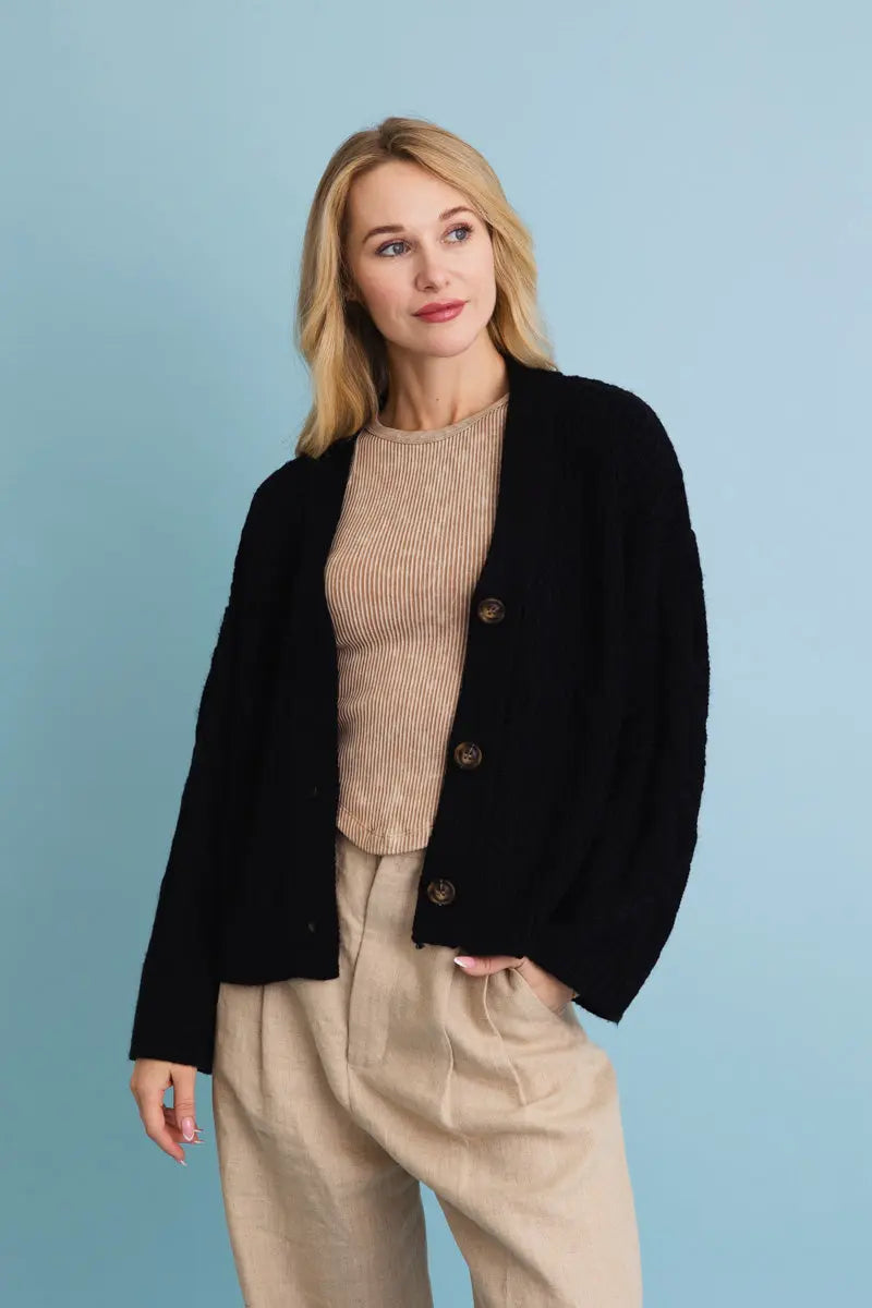 Black button-front textured cardigan with long sleeves; front view.