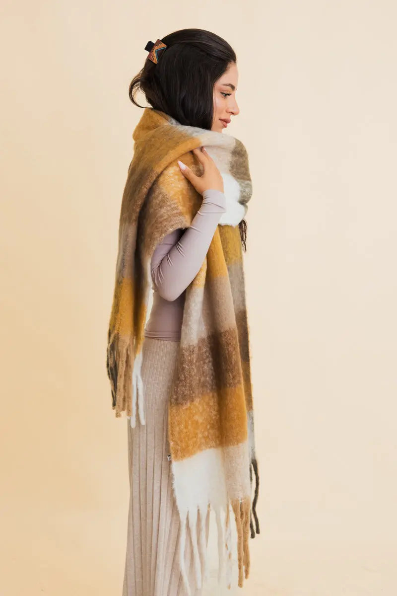 Oversized plaid fringe scarf with color blocks in olive, mustard, gray, and white