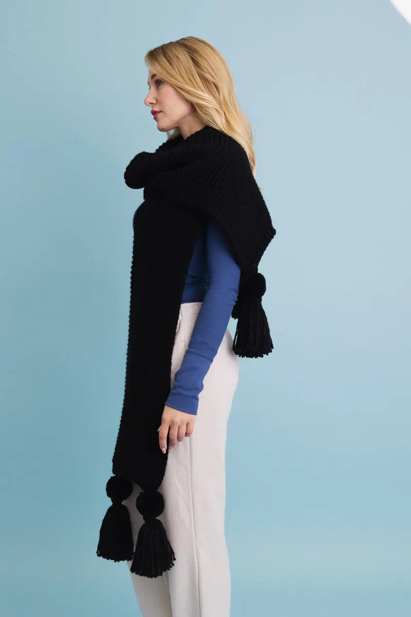 Black knit scarf with oversized tassel pom-poms along the edges