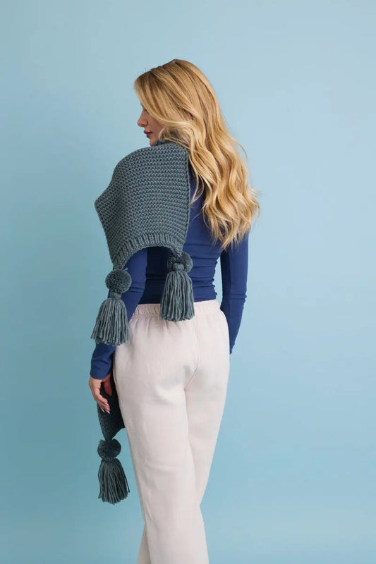Slate gray knit scarf with hanging tassel pom-poms along the lower edges