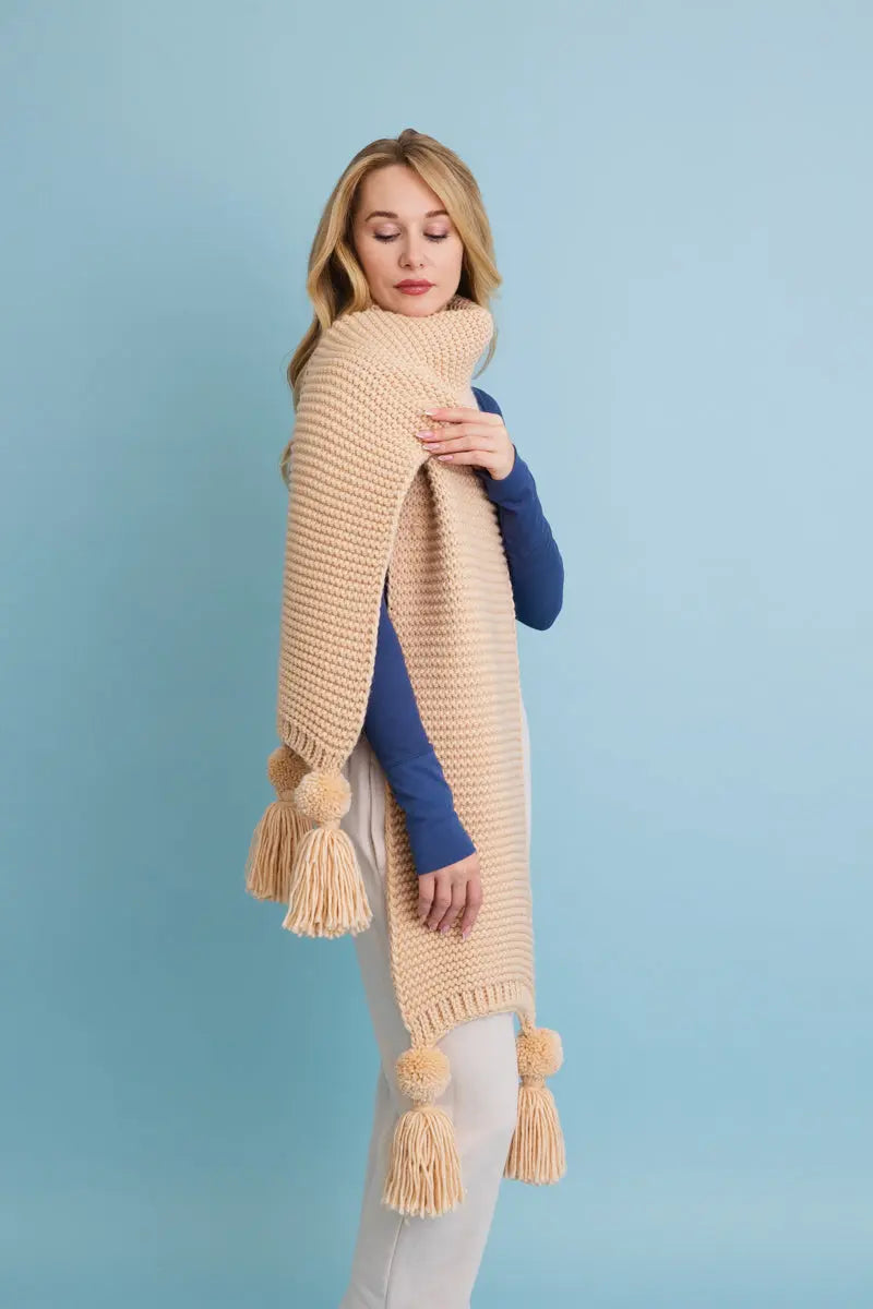 Tan knit scarf with large tassels and chunky ribbed texture