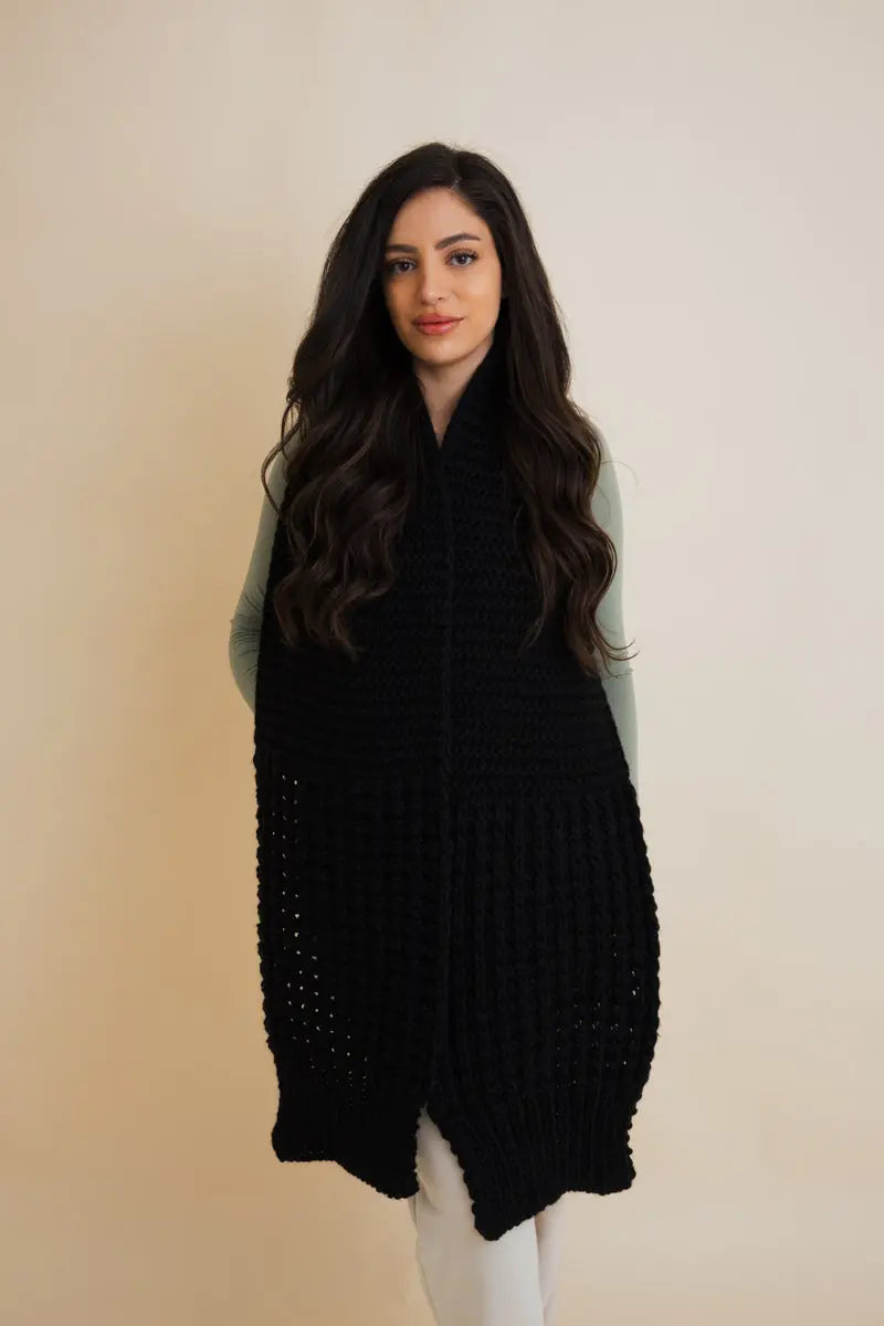 Black waffle-knit scarf with long wrap shape, draped over both shoulders