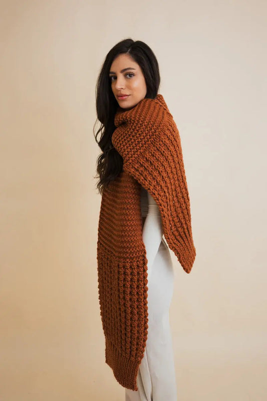 Rust-brown waffle-knit scarf with fringe ends, worn over one shoulder